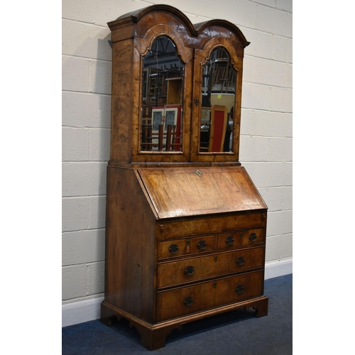 184 - A QUEEN ANNE (CIRCA 1710) FIGURED WALNUT DOUBLE DOME TOP BUREAU BOOKCASE, the double bevelled edge m... 