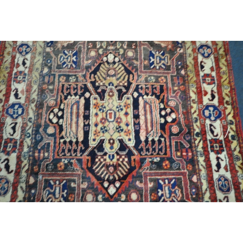 189 - A LARGE RECTANGULAR WOOLEN RUG, with mirrored and repeating geometric patterns, surrounded by a mult... 