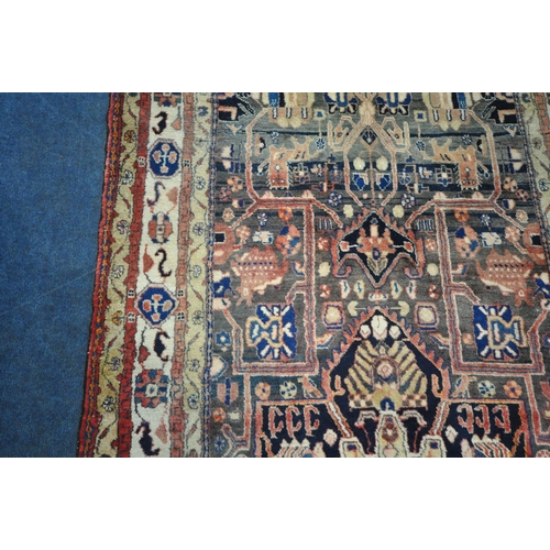 189 - A LARGE RECTANGULAR WOOLEN RUG, with mirrored and repeating geometric patterns, surrounded by a mult... 