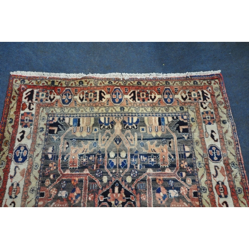 189 - A LARGE RECTANGULAR WOOLEN RUG, with mirrored and repeating geometric patterns, surrounded by a mult... 