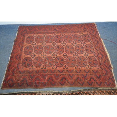 190 - A RED GROUND RECTANGULAR AFGHAN RUG, with twenty-one central medallions, surrounded by a multi-strap... 