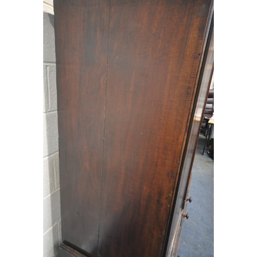 225 - A GEORGIAN MAHOGANY WARDROBE, with double cupboard doors, on a base with two short over one long dra... 