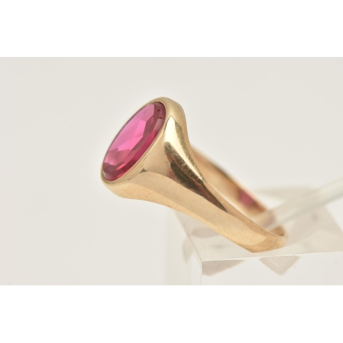 402 - A 9CT GOLD RUBY SIGNET RING, of an oval form set with a polished ruby assessed as synthetic, collet ... 