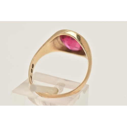 402 - A 9CT GOLD RUBY SIGNET RING, of an oval form set with a polished ruby assessed as synthetic, collet ... 