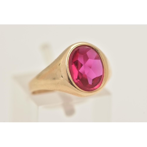 402 - A 9CT GOLD RUBY SIGNET RING, of an oval form set with a polished ruby assessed as synthetic, collet ... 