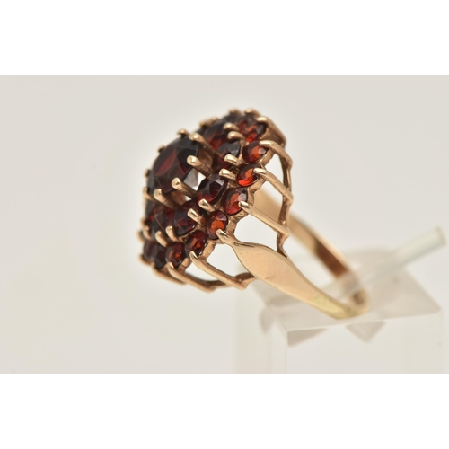 406 - A 9CT GOLD GARNET CLUSTER RING, of a circular form,  claw set with a cluster of circular cut garnets... 