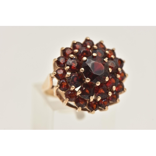 406 - A 9CT GOLD GARNET CLUSTER RING, of a circular form,  claw set with a cluster of circular cut garnets... 