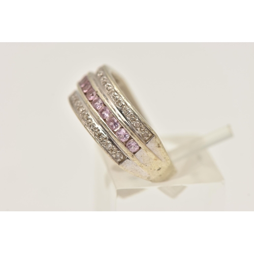 407 - A WHITE METAL GEM SET RING, designed as a central row of circular cut pink sapphires, between two ro... 