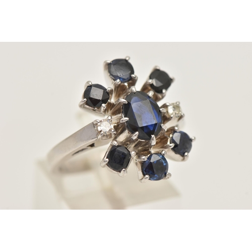 416 - A WHITE METAL SAPPHIRE AND DIAMOND CLUSTER RING, set with a central oval cut sapphire, flanked with ... 