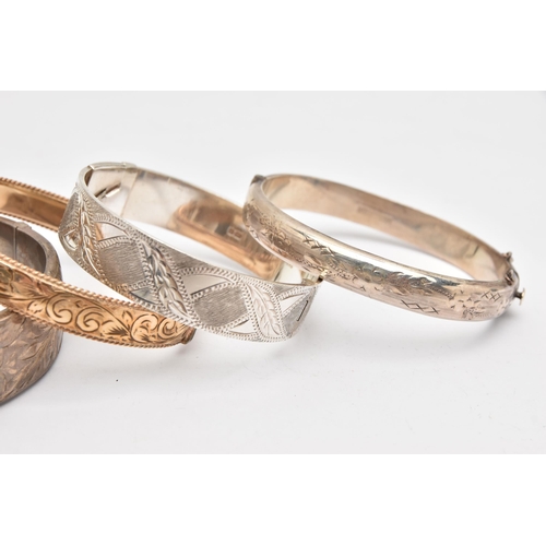 504 - THREE SILVER BANGLES AND A ROLLED GOLD BANGLE, three hinged bangles with etched detail, each hallmar... 