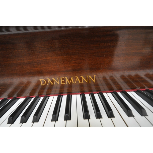 152 - A DANEMANN MAHOGANY CASED BABY GRAND PIANO, the hinged lid enclosing a cast iron over strung frame, ... 