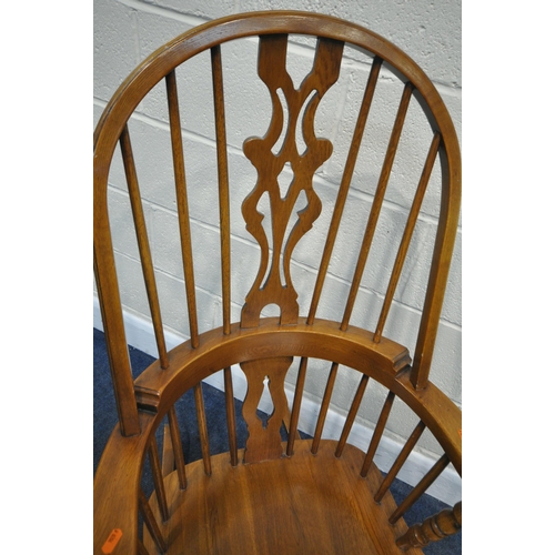 224 - A 20TH CENTURY OAK ROCKING CHAIR, with a central splat, swept armrests, raised on turned supports, w... 