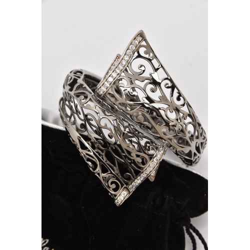 491 - TWO WHITE METAL BANGLES, the first a hinged open work cuff bangle set with cubic zirconia, signed 'B... 