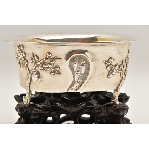 580 - AN EARLY 20TH CENTURY CHINESE SILVER JARDINIERE WITH HARDWOOD BASE, of an oval form, embossed pronus... 