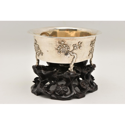 580 - AN EARLY 20TH CENTURY CHINESE SILVER JARDINIERE WITH HARDWOOD BASE, of an oval form, embossed pronus... 