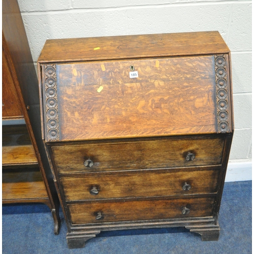 185 - AN EARLY 20TH CENTURY OAK BUREAU, the fall front door enclosing a fitted interior, above three drawe... 