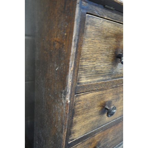 185 - AN EARLY 20TH CENTURY OAK BUREAU, the fall front door enclosing a fitted interior, above three drawe... 