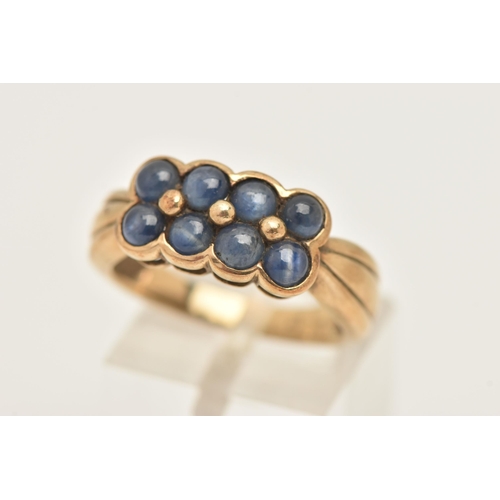 425 - A 9CT YELLOW GOLD SAPPHIRE DRESS RING, designed as two rows of sapphire cabochons, to the grooved sh... 