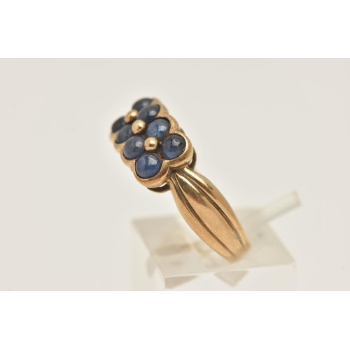 425 - A 9CT YELLOW GOLD SAPPHIRE DRESS RING, designed as two rows of sapphire cabochons, to the grooved sh... 