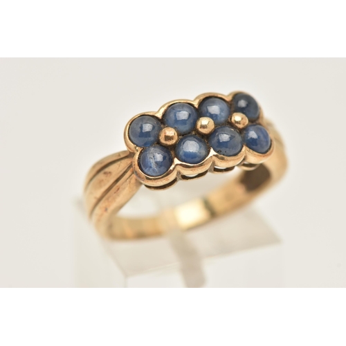 425 - A 9CT YELLOW GOLD SAPPHIRE DRESS RING, designed as two rows of sapphire cabochons, to the grooved sh... 