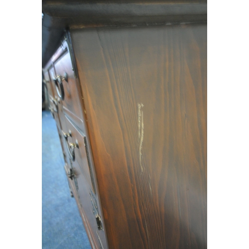 175 - A REPRODUCTION KOREAN ELM LOW CABINET, with a shaped top, brass mounts, six assorted drawers, over d... 