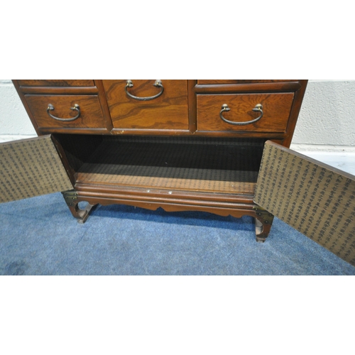 175 - A REPRODUCTION KOREAN ELM LOW CABINET, with a shaped top, brass mounts, six assorted drawers, over d... 