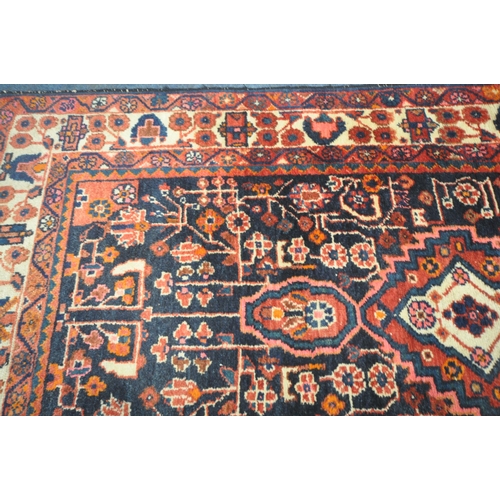 181 - AN IRANIAN WOOLEN RUG, with repeating geometric patterns, surrounded by a multi-strap border, 260cm ... 