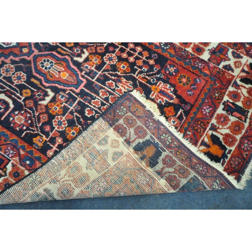 181 - AN IRANIAN WOOLEN RUG, with repeating geometric patterns, surrounded by a multi-strap border, 260cm ... 