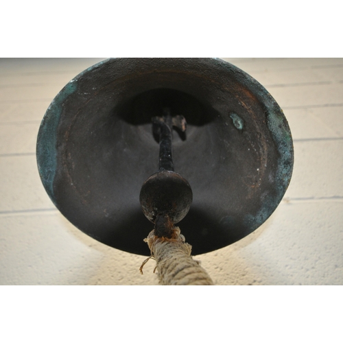 190 - A GEORGE VI BRASS BELL, engraved G R VI, with a hanging striker and rope handle, attached to a white... 