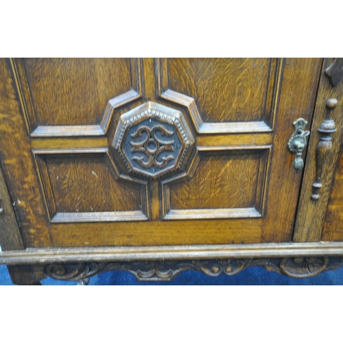 192 - A 20TH CENTURY OAK SIDEBOARD, with a raised back, fitted with double cupboard doors, a scrolled apro... 