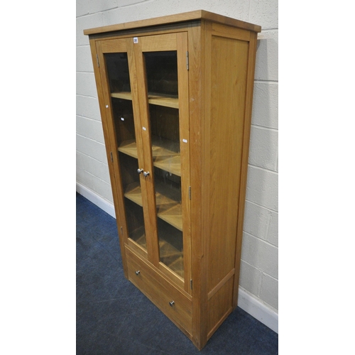 201 - A MODERN OAK DISPLAY CABINET, with double glass doors, over a single deep drawer, width 81cm x depth... 