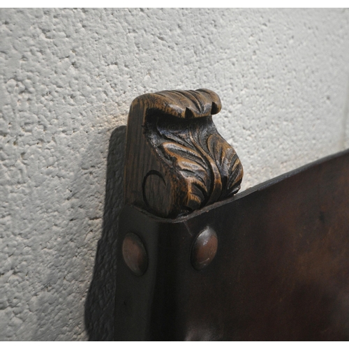 204 - A SET OF FOUR OAK CHAIRS, with brown leather back rest and seat, foliate and scrolled carved details... 