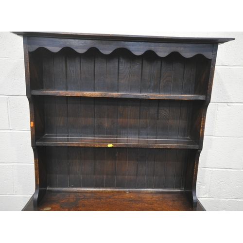 218 - A 20TH CENTURY OAK DRESSER, the two tier plate rack, atop a base with two drawers, over double cupbo... 