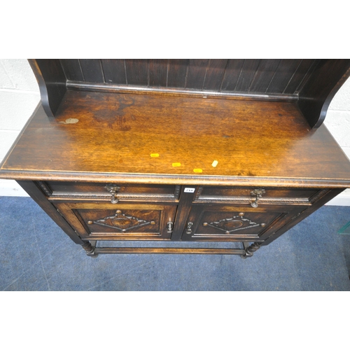 218 - A 20TH CENTURY OAK DRESSER, the two tier plate rack, atop a base with two drawers, over double cupbo... 