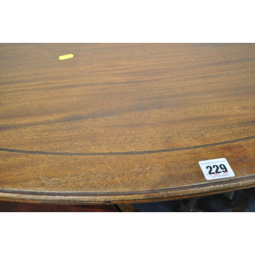 229 - A 20TH CENTURY MAHOGANY OVAL TILT TOP TABLE, raised on a turned support and four legs, width 136cm x... 