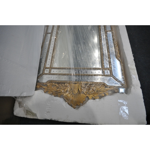 231 - A NEW IN BOX VENETIAN WALL MIRROR, with a foliate gilt frame, 65cm x 140cm, condition report: new in... 