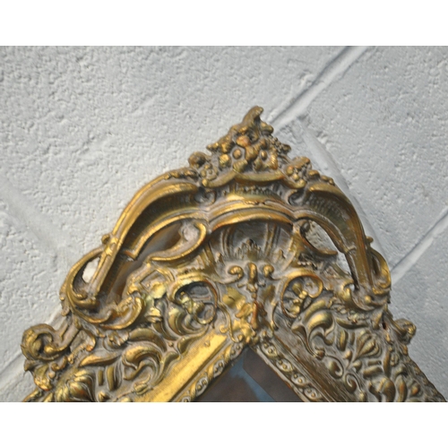 239 - PEERART WORKS COLNE LANCASHIRE ENGLAND, A GILT FRAME BEVELLED EDGE WALL MIRROR, with intricate detai... 