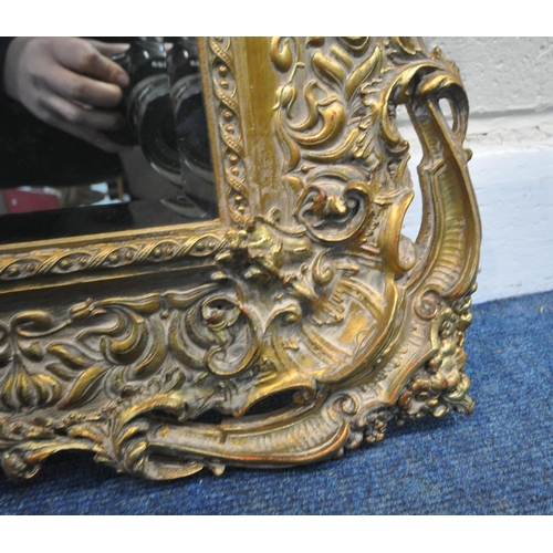 239 - PEERART WORKS COLNE LANCASHIRE ENGLAND, A GILT FRAME BEVELLED EDGE WALL MIRROR, with intricate detai... 