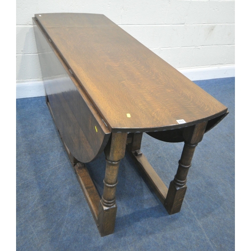 257 - NIGEL GRIFFITHS, A REPRODUCTION SOLID OAK GATE LEG TABLE, raised on block and turned legs, diameter ... 