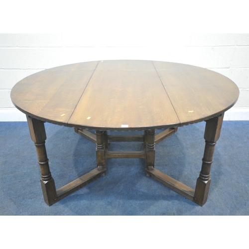 257 - NIGEL GRIFFITHS, A REPRODUCTION SOLID OAK GATE LEG TABLE, raised on block and turned legs, diameter ... 