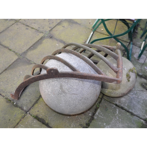 9 - A VINTAGE CAST IRON HAY RACK AND TWO RECONSTITUTED STONE SPHERES, the rack is 80cm across, the spher... 