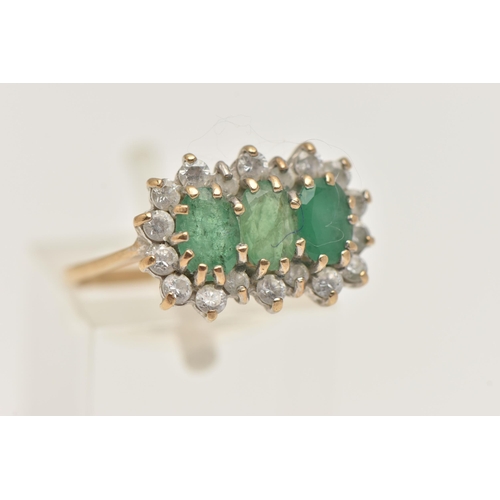 402 - A 9CT GOLD EMERALD CLUSTER RING, designed as three oval cut emeralds each in a claw setting, within ... 