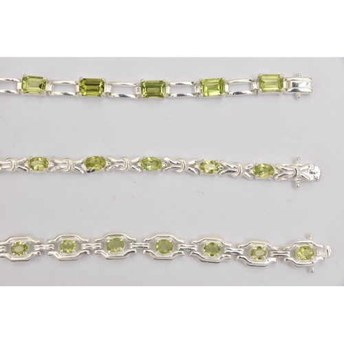 449 - THREE WHITE METAL GEM SET LINE BRACELETS, different designs, all set with peridots, fitted with inte... 