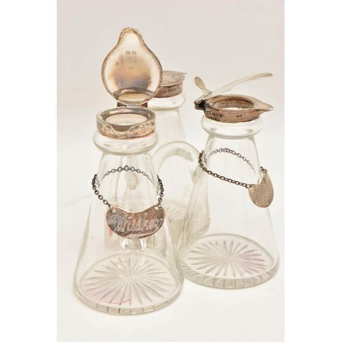 516 - THREE SILVER MOUNTED WHISKEY TOT GLASSES, three tapered glass bottles, each fitted with silver hinge... 