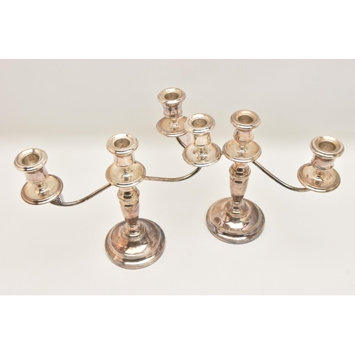 528 - A PAIR OF ELIZABETH II SILVER THREE BRANCH CANDLESTICKS, tapered stems on round weighted bases, hall... 