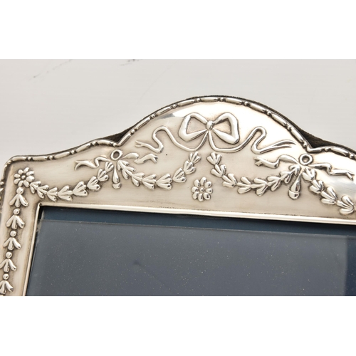 543 - A LARGE SILVER PHOTO FRAME, decorated with a bow and swag pattern, blue suede backing with easel, ha... 