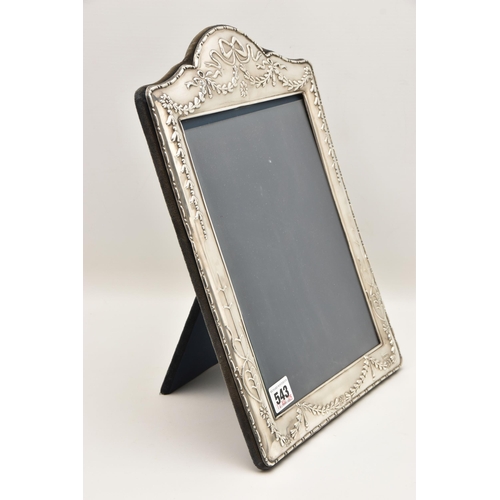 543 - A LARGE SILVER PHOTO FRAME, decorated with a bow and swag pattern, blue suede backing with easel, ha... 