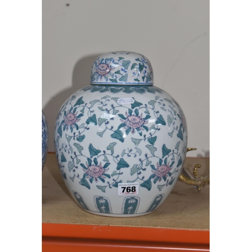 768 - TWO LARGE ORIENTAL STYLE GINGER JARS, comprising a blue and white covered jar with swirling fern des... 