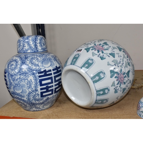 768 - TWO LARGE ORIENTAL STYLE GINGER JARS, comprising a blue and white covered jar with swirling fern des... 