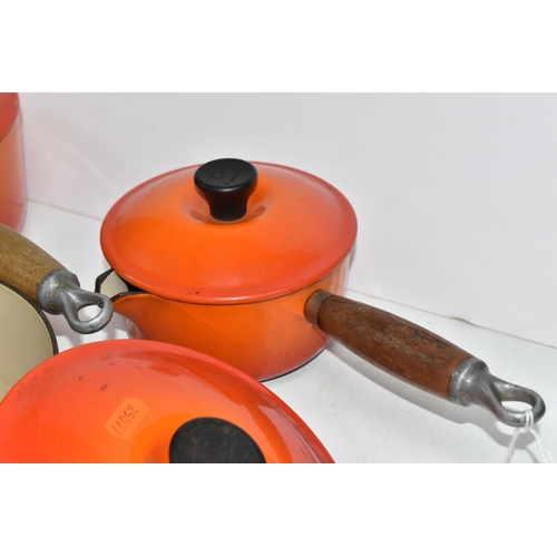 793 - THREE VINTAGE LE CREUSET PANS WITH TWO EXTRA LIDS in 'Volcanic Orange' colours all with wooden handl... 